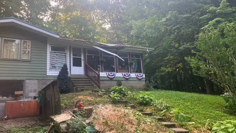 The same house after the fallen tree was removed, with the yard cleared and raked clean